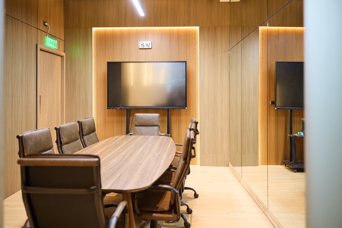 Sala conferenze moderna con tavolo ovale e sedie in pelle.